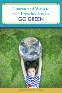 Little girl on grass holding up globe