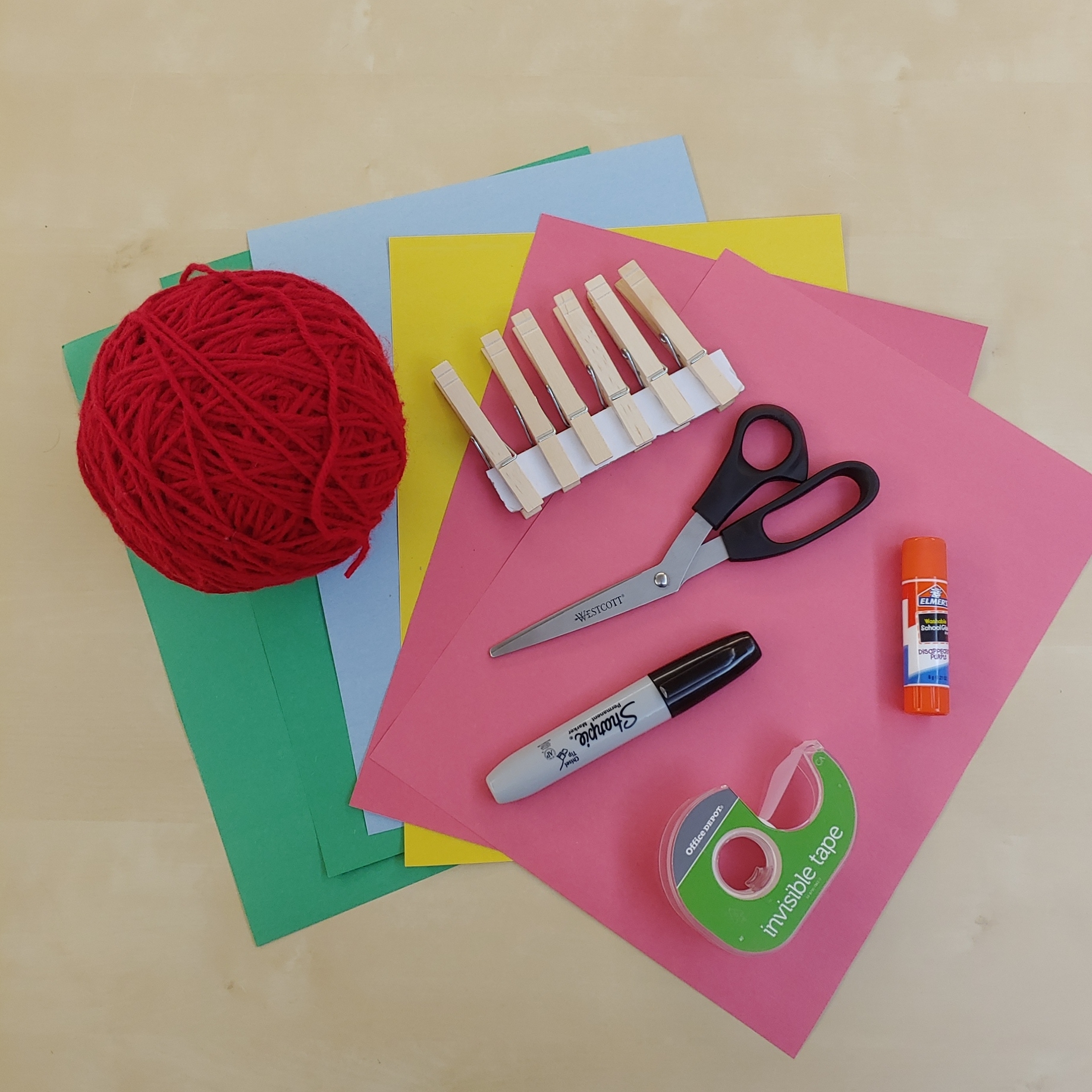 Yarn, scissors, tape, glue stick, Sharpie, construction paper, wooden clothespins