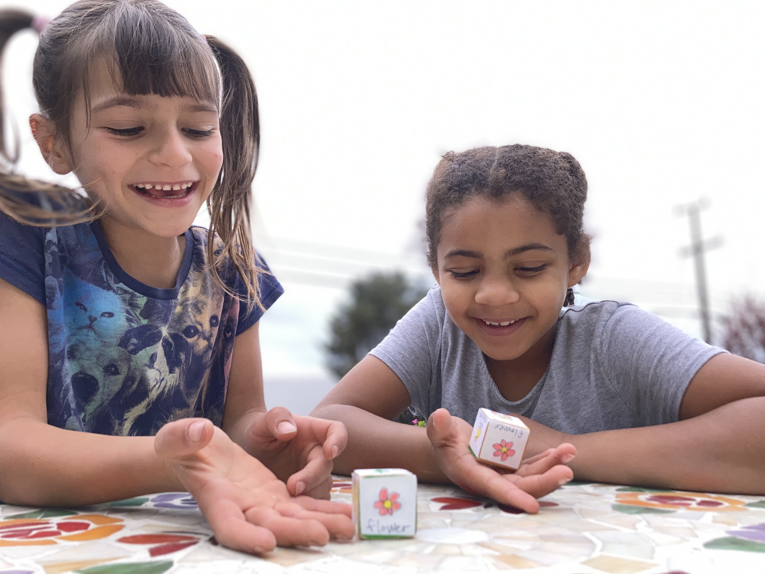Two girls playing with Easter storytelling dice