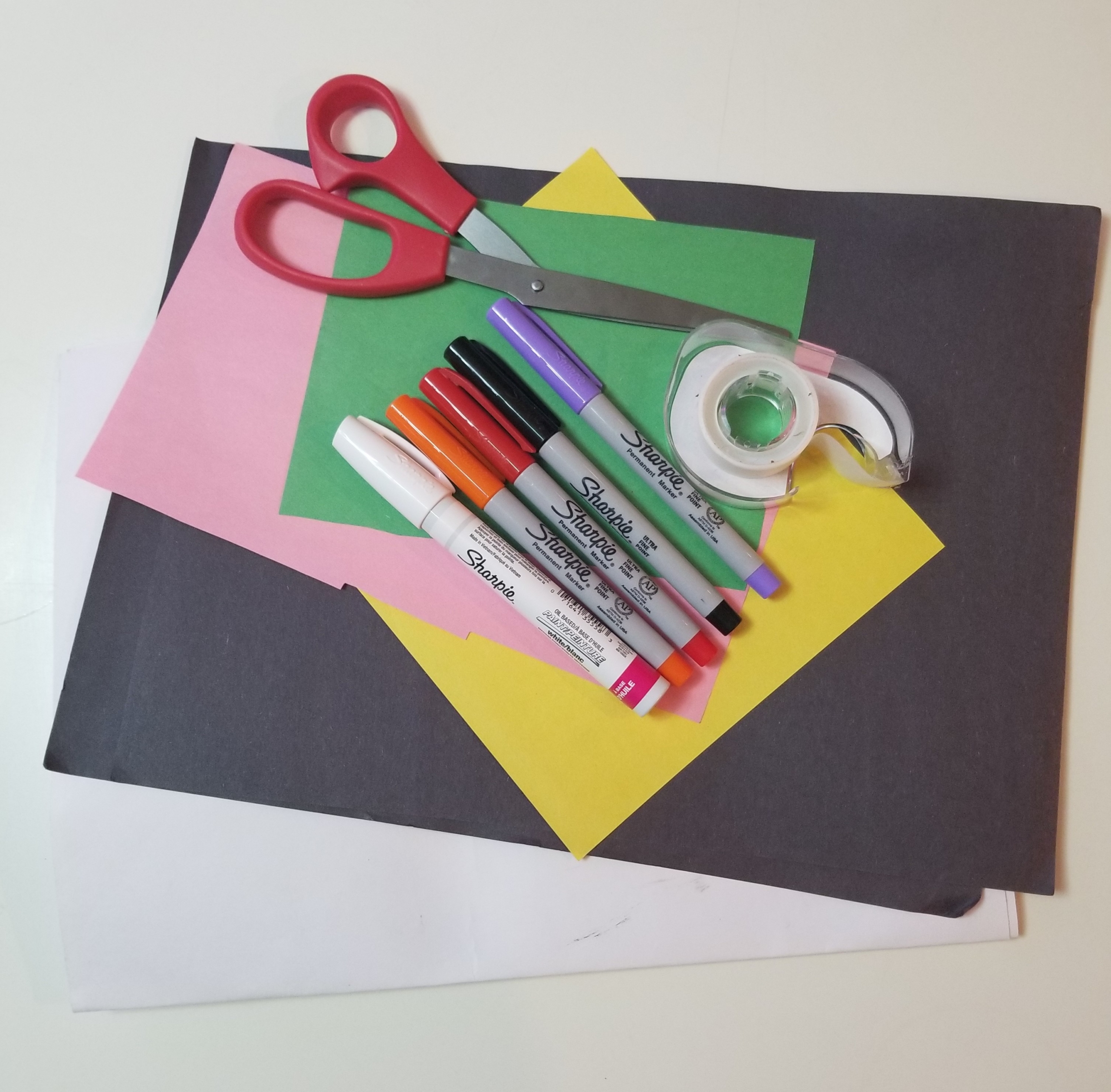 A pile of construction paper, scissors, tape, and sharpies 