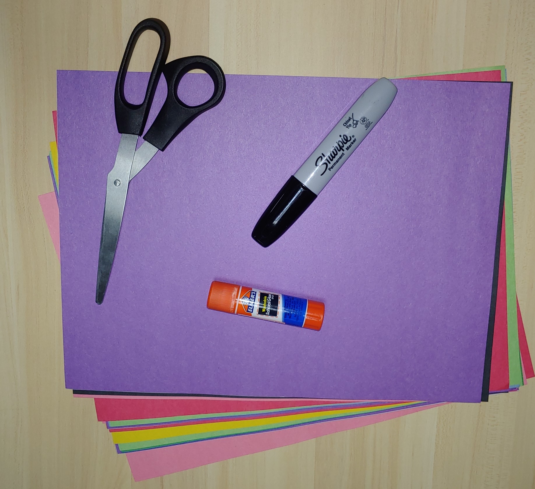 Stack of construction paper, scissors, glue stick, and sharpie 
