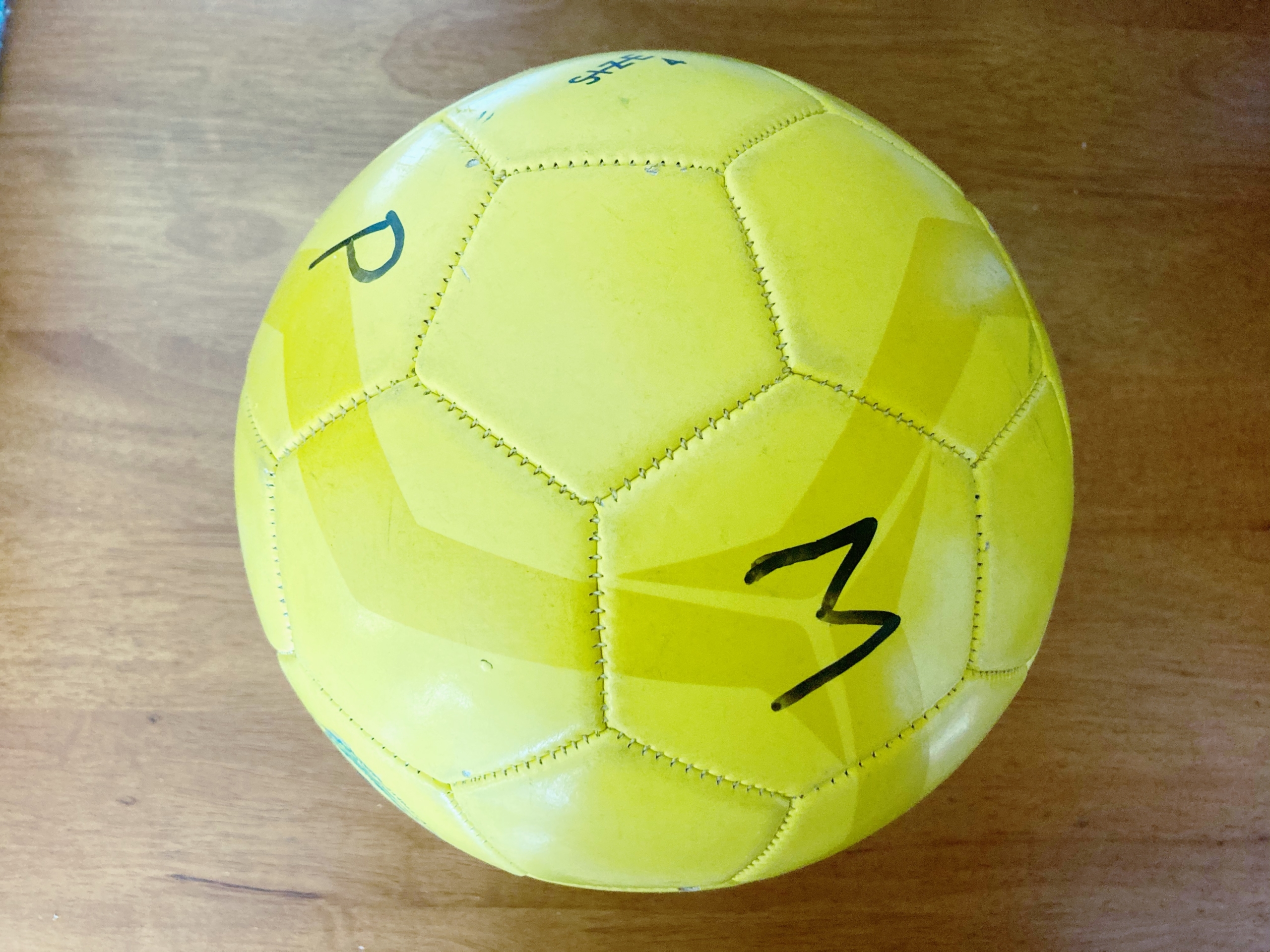 Yellow soccer ball with individual letters written on it
