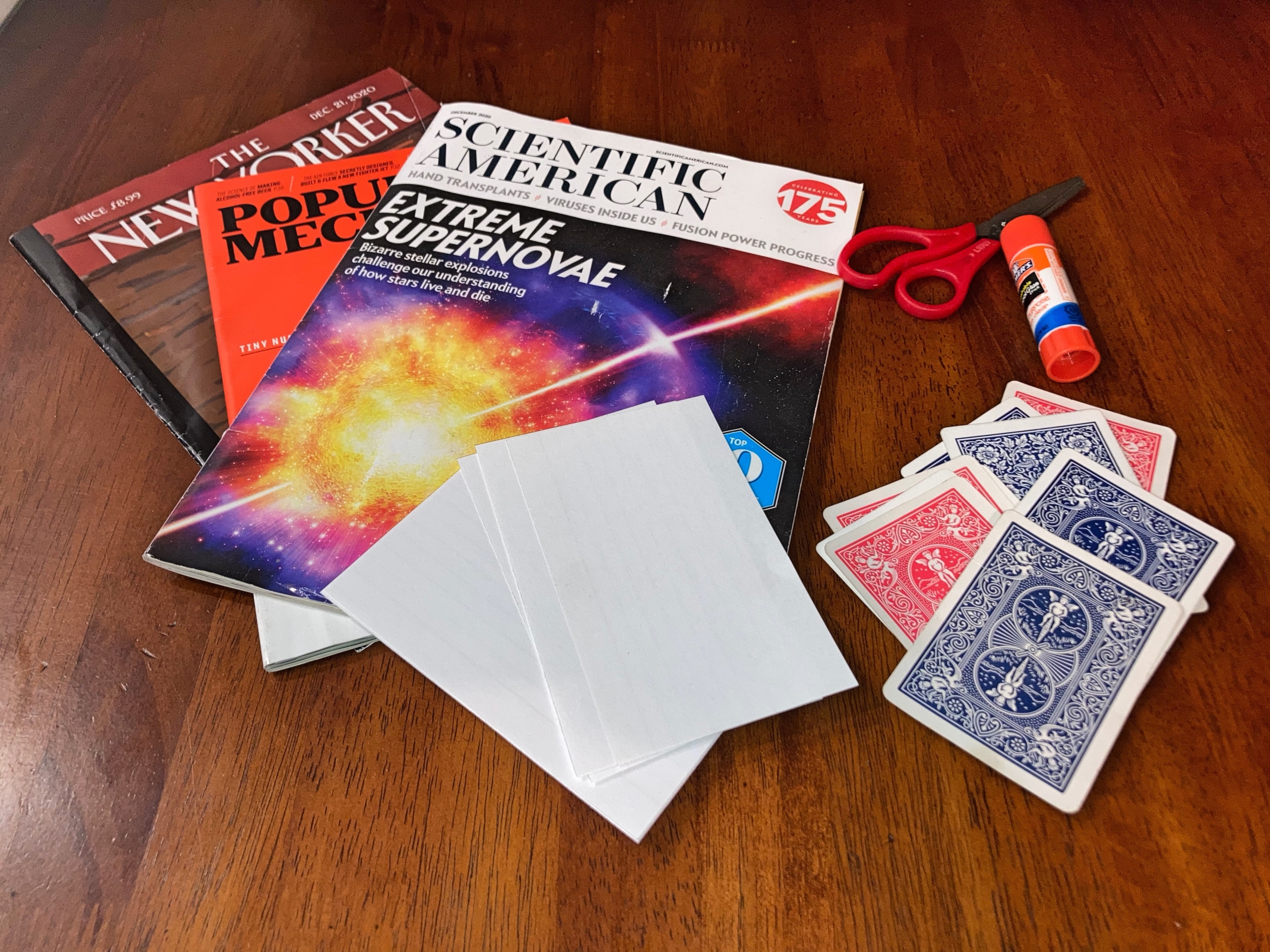 Pile of magazines, playing cards, glue and index cards